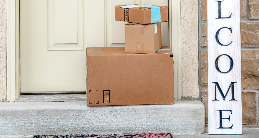 Packages on the doorstep of a home with a welcome sign in Santa Fe